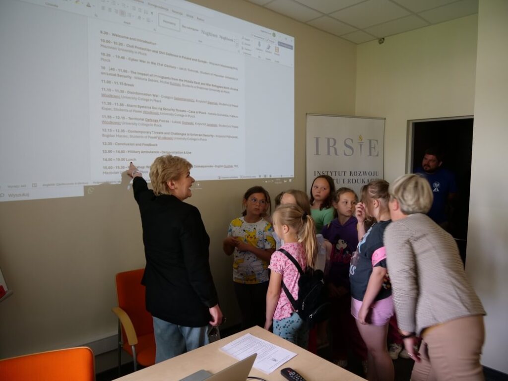 Uczniowie oglądają plan dnia wyświetlany na ścianie projektorem
